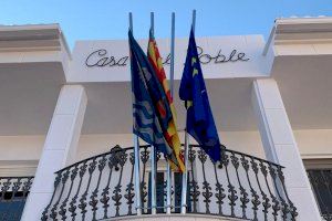 Grimpen per la façana de l'Ajuntament de Beniflà per a robar la bandera d'Espanya