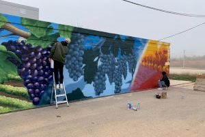 Los participantes en el Taller de Graffiti de Requena pintan un mural en el Recinto Ferial