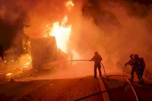 Los bomberos tratan de apagar las llamas del camión accidentado