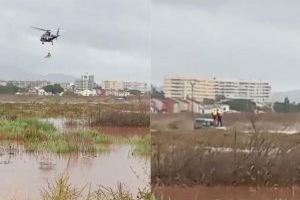 Unos bomberos en prácticas rescatan con helicóptero a un vehículo atrapado por el agua en Benicàssim