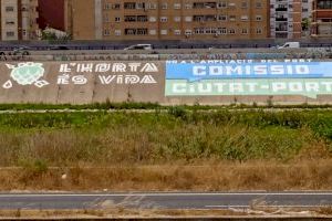 El nou llit del Túria clareja amb una gran pintada en contra de l'ampliació del Port de València