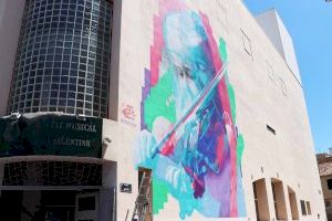 La artista La Oliwa está realizando su mural artístico en la pared lateral del Bingo sala Mónaco de Puerto de Sagunto