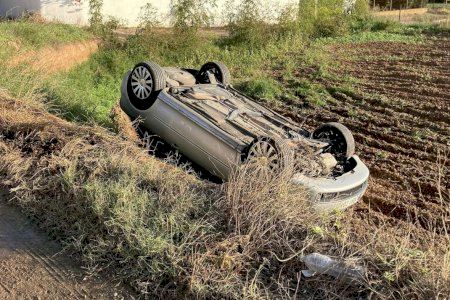 Un aparatós accident a Albal acaba amb la bolcada d'un cotxe en plena horta